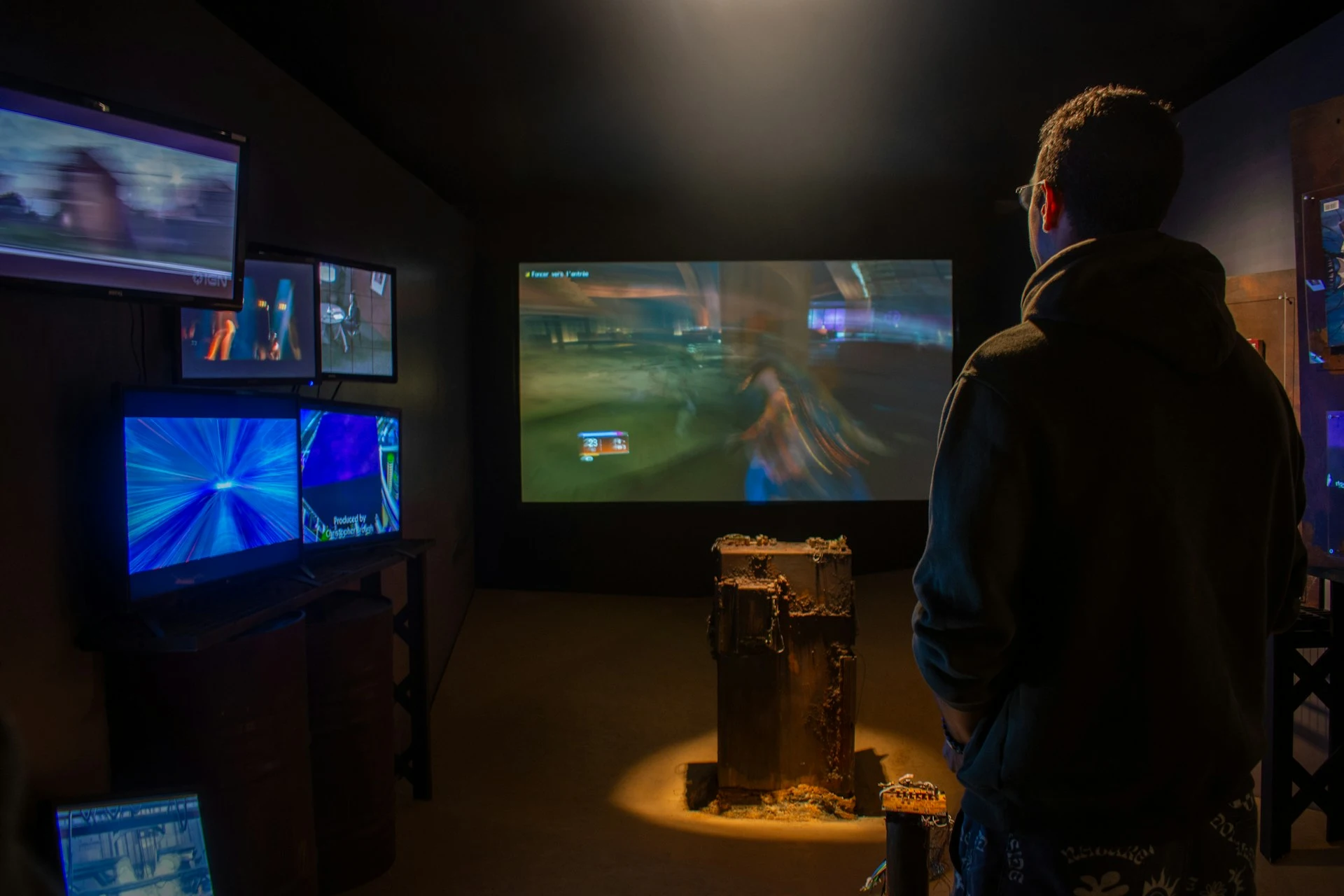 Joueur devant plusieurs écrans de jeux vidéo