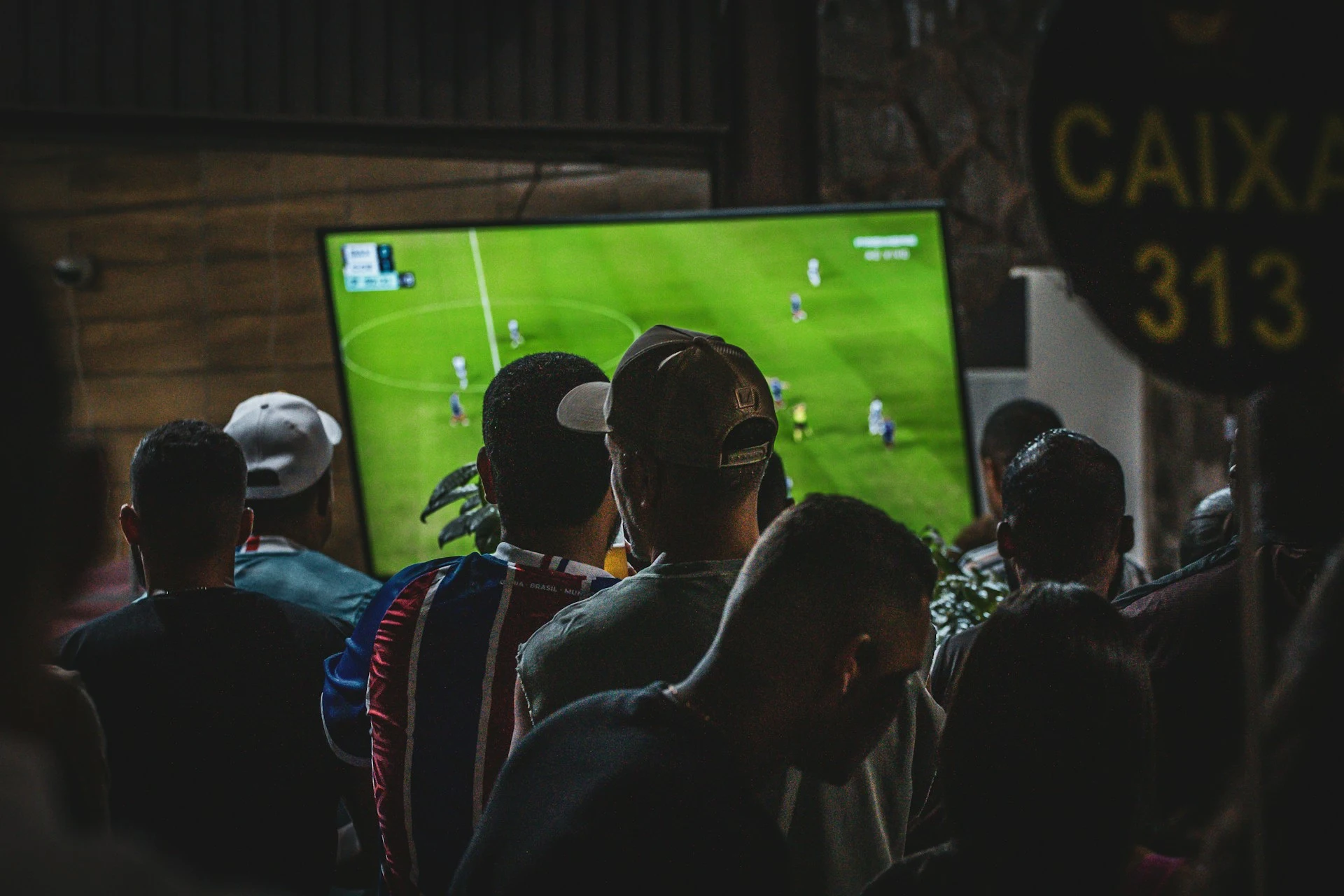 Supporters regardant un match de football dans un bar