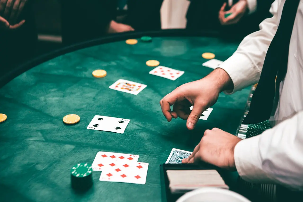 Les mains du croupier de casino distribuant les cartes à une table de jeu